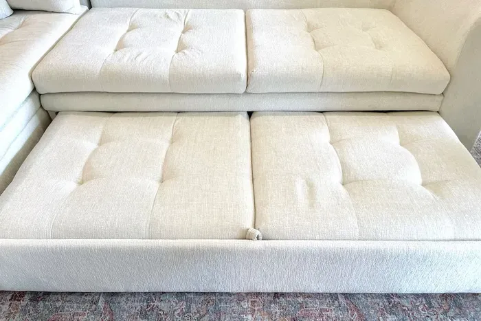 Pull out bottom section of the couch, works best with 2 people to pull out evenly and then pull up to extend the bed.