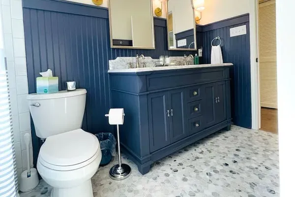 Beautiful fully remodeled hall bathroom with double sinks, toilet, shower and tub.
