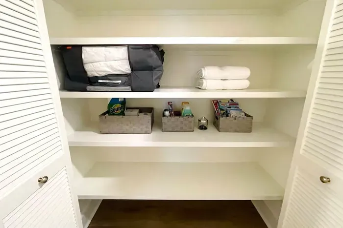 Hall closet with extra towels, sofa bed bedding, amenity basket, activity basket and extra paper supplies.