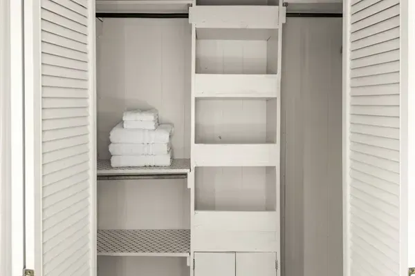 Discover the convenience of a meticulously organized closet in this home, complete with clean towels and ample storage space.