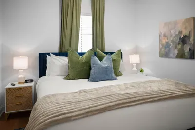 Relax in this inviting bedroom featuring plush bedding, soft lighting, and calming décor.