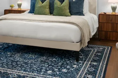 Comfortable bedding and a beautiful patterned rug add warmth and style to this inviting bedroom.