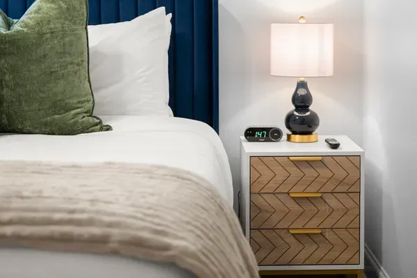 Thoughtful bedroom details, from the stylish nightstand to the soft bedside lighting.