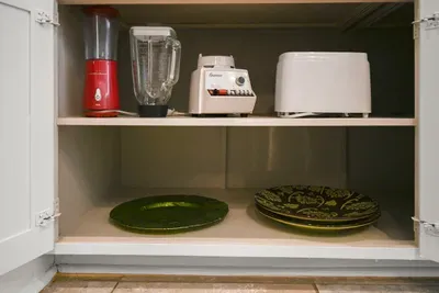 Extra kitchen essentials, including small appliances and serving pieces, are ready for your use.