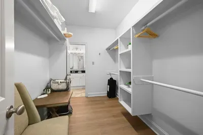 Stay organized with this generous walk-in closet featuring built-in shelving and plenty of room for your belongings.