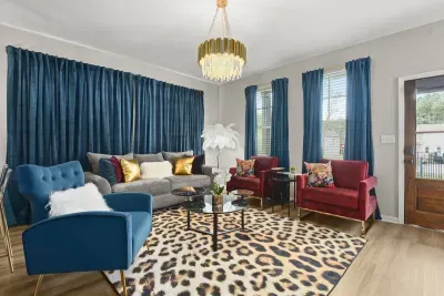 /Elegant allure: Blue curtains and chandelier grace our elite living room
