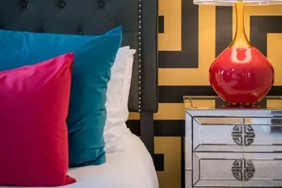Plush decorative pillows and a charming red lamp that adds a pop of color and coziness