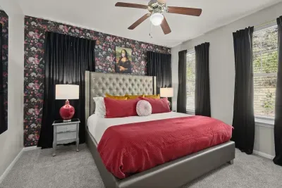 Bedroom 4: Encounter artful sophistication and restful nights in our designer home, featuring a sumptuous bed and an iconic Mona Lisa portrait that adds a touch of timeless elegance.