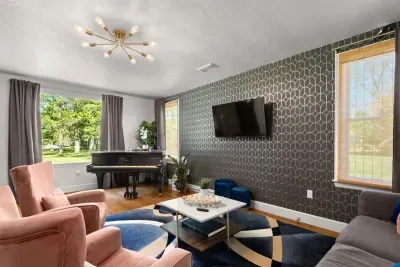 Bask in the vibrant charm of the living room, where a colorful carpet complements the classic couch, infusing the space with timeless elegance and cozy comfort