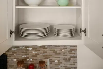 Organized elegance: Clean plates and bowls neatly stored in the kitchen cabinets for your convenience