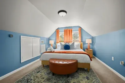 Serene escape: Light blue tones and vibrant pillows create a cozy, colorful haven