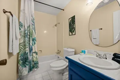 Elegant design: The second bathroom features cream wallpaper and a refreshing green leafy shower curtain