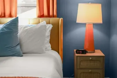 Warm ambiance: The orange bedside lamp adds a cozy, vibrant touch to the room