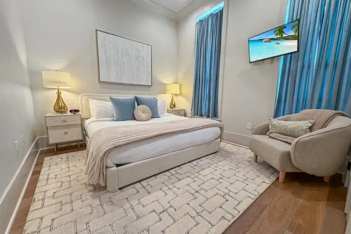 Cozy bedroom retreat with high ceilings, natural light, and a touch of modern comfort