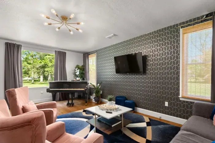 Bask in the vibrant charm of the living room, where a colorful carpet complements the classic couch, infusing the space with timeless elegance and cozy comfort