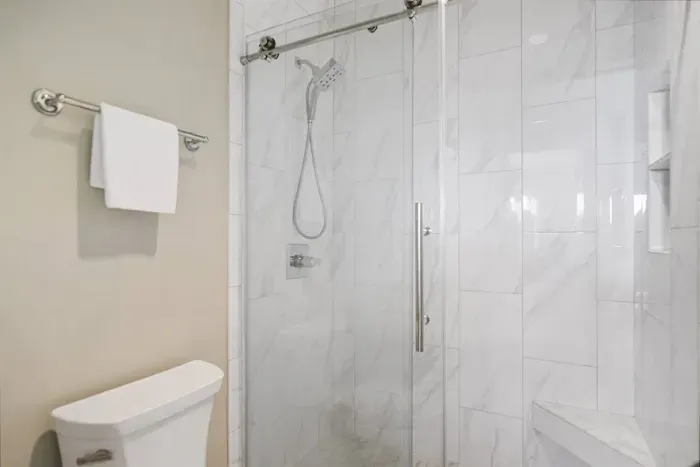 Spacious master shower with luxury tile & sliding glass door.