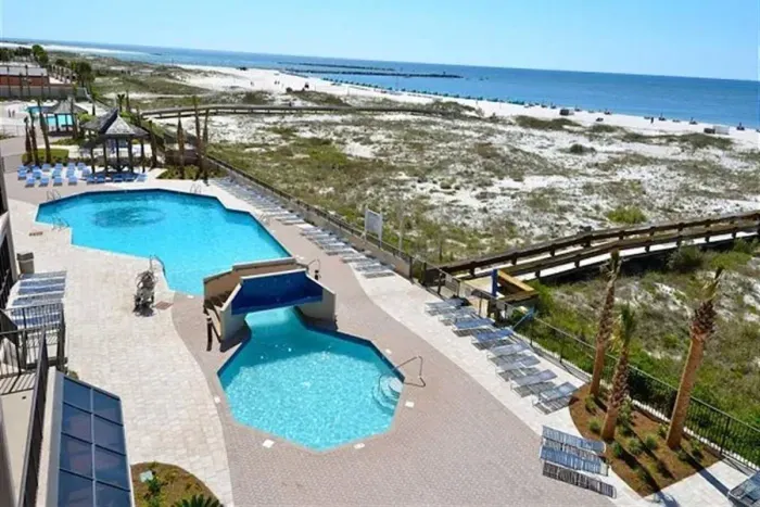 Pool, board walk to beach and jetty pass in the background.