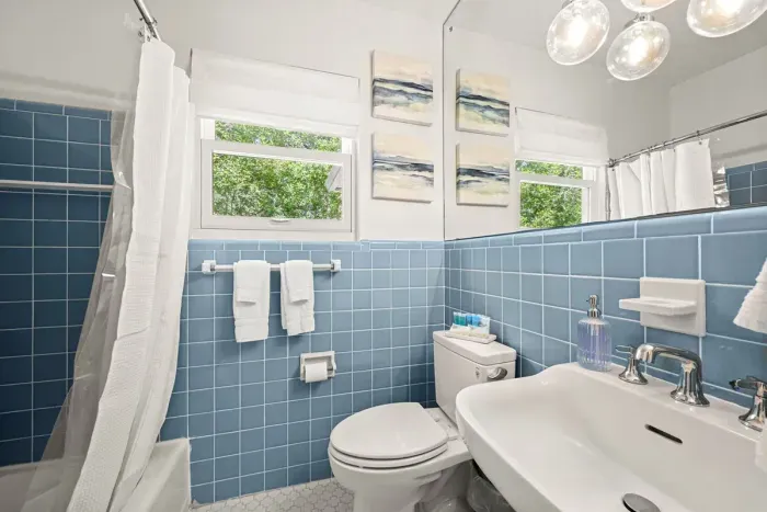 Bathroom Haven: Bright blue tiles and natural light create a refreshing retreat for your stay!