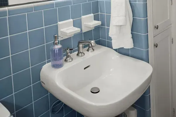 Charming Bathroom: Bright blue tiles and modern lighting create a refreshing retreat.