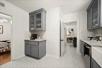 Charming Kitchenette: Stylish gray cabinets and modern appliances await your culinary adventures!