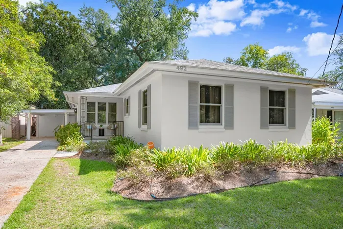 Charming Exterior: Explore vibrant gardens and enjoy the inviting porch in this Baton Rouge gem!