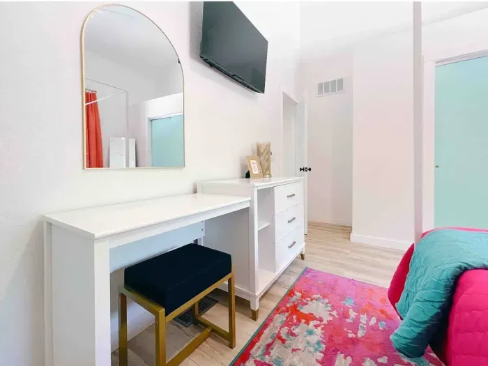 Main Level Bedroom with Workspace/Vanity  + Dresser. Roku Tv, King Size Canopy Bed, Closet & Full -Size mirror + 2 bedside vanities + underbed storage. 