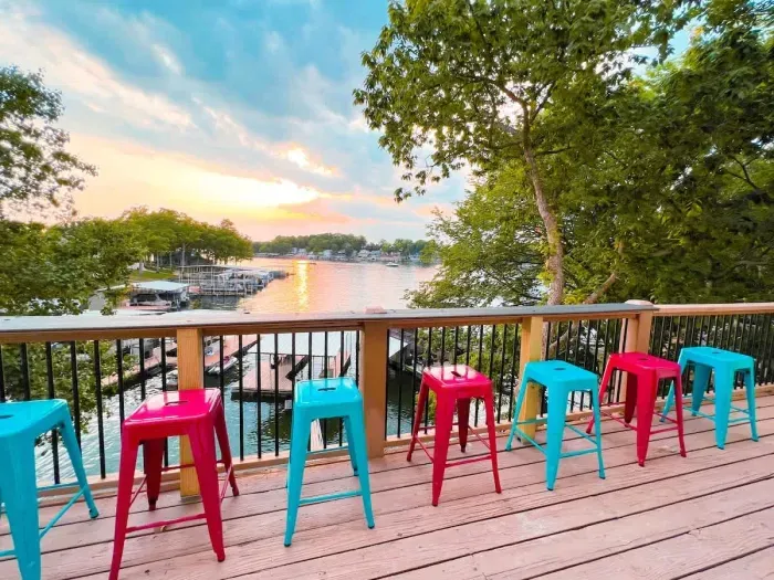 Upper deck balcony seating overlooking the lower deck & dock with sunset views & a ledge for eats & drinks!
