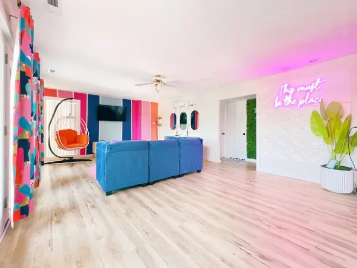 Alternate view of the lower level with Neon Selfie Wall, Roku Tv, a new/comfortable/modular sectional w/bar-style beauty area for getting ready & hanging accent chair (all new, colorful, bright & clean!)