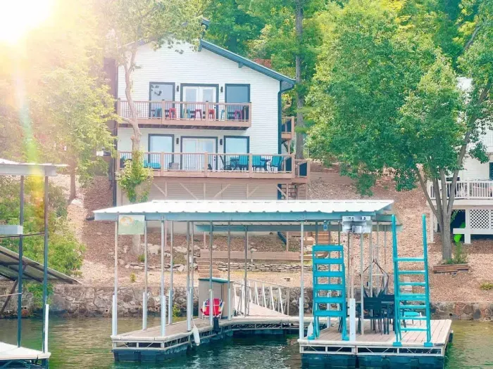 Exterior rear view of The Palm Lake Ozark showcasing the 2 level decks with dining/lounge space, private dock with wet steps, high dive, etc & boat slip 10x25 for use just steps away from the main house!
