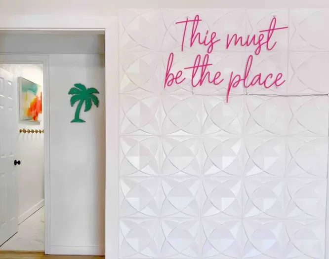 Neon "Selfie Wall" with the lower level bathroom in the background.