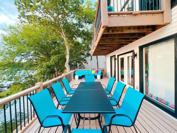 Alternate view of the lower level deck that provides access to the lower level of the property and pathway to the private dock & lake. Pictured is the Dining for 8 & the outdoor sofa sectional in the back providing extra seating.
