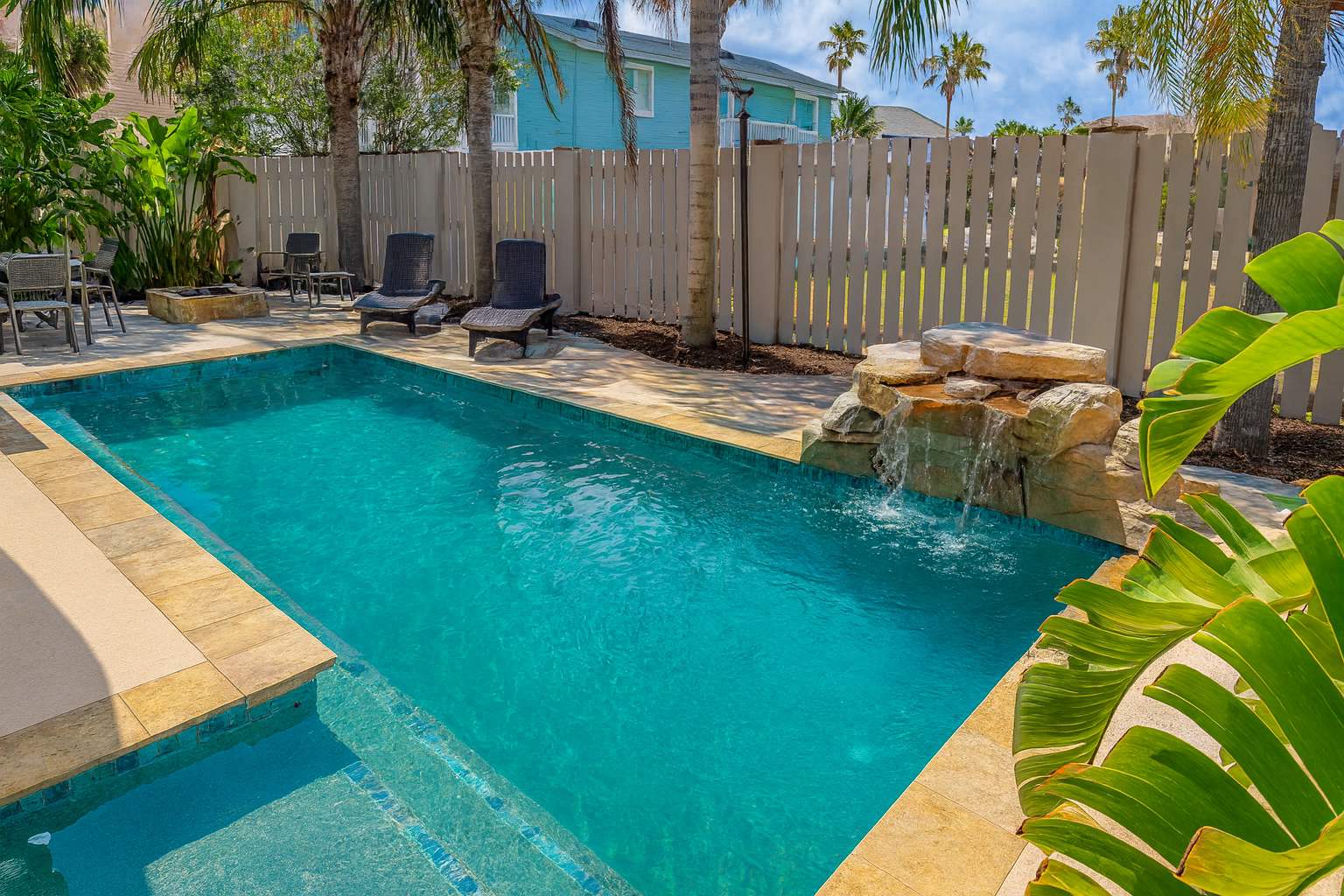 Tropical Pool Retreat w/ Waterfall Spa, Palm-Lined Privacy Fence & Sunlit Lounge Deck
Unwind in this private oasis featuring a sparkling pool, soothing waterfall, tropical landscaping, and lounge seating.