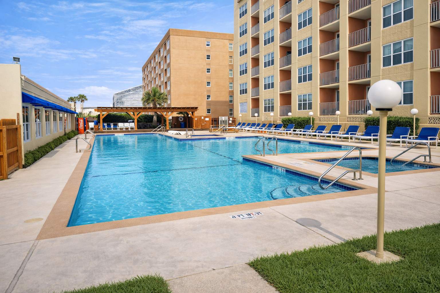 Resort-style pool retreat with shaded pergola, lounge chairs, and Gulfview II balconies—perfect for relaxing under the sun.