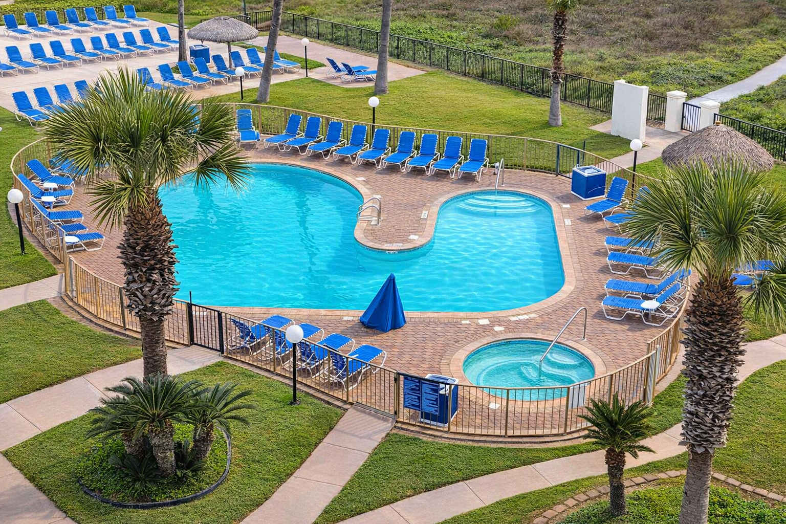 Resort-style pool retreat with outdoor tub, palm trees, and lounge seating—perfect for relaxing coastal getaways. Steps from beach access, ideal for families or couples seeking sun-soaked leisure.