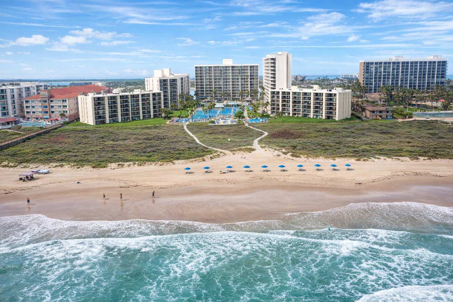 Beachfront resort with ocean views, poolside paradise, and direct beach access—perfect for family getaways or romantic escapes. Walk to the waves, relax under blue umbrellas, and enjoy spacious condos with private balconies and lush landscaping.