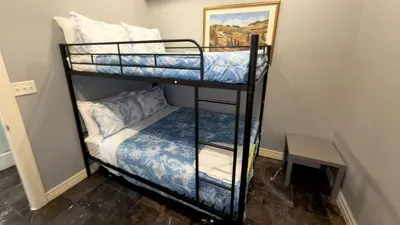Bunk Room Perfect for Kids
Sleep soundly in a cozy bunk room featuring sturdy metal bunks with matching blue floral bedding, sleek tile floors, and a bedside table, ideal for kids, friends, or extra guests on your beach getaway.