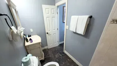 Modern Bathroom with Walk-In Shower
Freshen up in a bright bathroom featuring a sleek vanity, tiled walk-in shower, plush towels, and essential toiletries, offering a clean and comfortable space to get ready for beach days or relaxing nights.