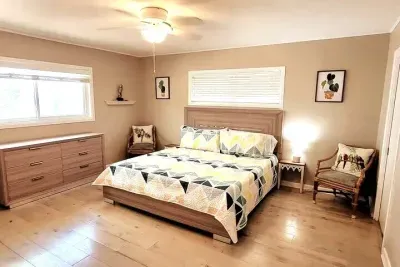 Relax in this bright, inviting bedroom featuring a plush comfy bed, warm natural light, modern décor, and thoughtful touches for comfort. Perfect for unwinding after a day of coastal adventures, with ample storage and a calm, cozy vibe.