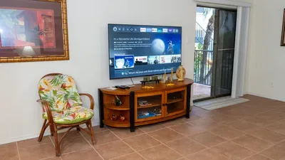 Bright, comfortable living area featuring a smart TV entertainment setup, cozy seating, warm décor, and easy access to the patio. Natural light and a relaxed layout create an inviting space perfect for unwinding and enjoying your stay.