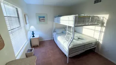 Bright, cozy bedroom featuring a clean bunk‑bed setup, soft natural light, beach‑themed décor, and simple, functional furnishings. Warm tones and thoughtful touches create a comfortable, family‑friendly space ideal for restful nights.