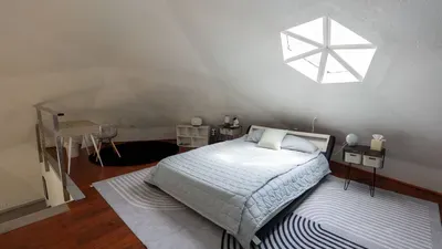 Relax in this serene, modern bedroom featuring a plush serene bed with soft blue linens and sleek tile flooring. Clean lines, neutral tones create a peaceful retreat perfect for unwinding after beach days.