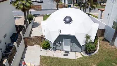 This eye‑catching dome home offers a bright white exterior, private walkway, and palm‑lined yard. Its unique architecture and peaceful outdoor space create a memorable island stay just minutes from beach access and local attractions.