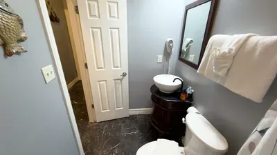 Cozy Coastal Half Bath
Adorable powder room feat. tropical fish decor, wood pedestal sink & fresh towels! Compact, clean & convenient w/ easy access. Perfect for quick refreshes during your stay.