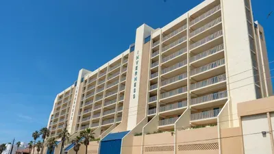 Inverness’ bright exterior showcases its classic coastal design with sweeping balconies and a warm palette. This oceanfront complex offers stunning views and direct beach access, inviting guests to experience the best of seaside living.