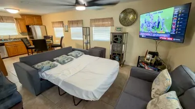 Versatile Sleeper Sofa Media Den
Pull-out sofa bed + 55" TV for movie nights or extra guests! Open to kitchen, fan-cooled in sunny yellow tones. Family-friendly at 113 E Pompano St—beach, harbor & SpaceX nearby.