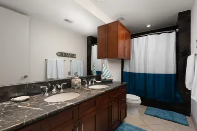 A calm, modern bathroom with soft tones, clean lines, and a relaxed layout that feels naturally welcoming. The simple styling and gentle details create an easy, unhurried atmosphere, offering a comfortable space to refresh throughout the stay.