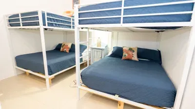 A bright, thoughtfully designed bunk room perfect for families or groups. Clean lines, cozy blue tones, and smart layout create a welcoming retreat that feels both spacious and intimate for restful coastal stays.
