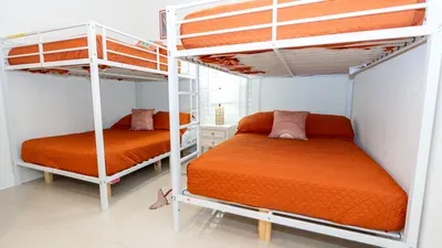 A bright, well‑designed bunk space with warm orange tones and clean lines, offering a cozy setup that feels welcoming for families and groups. Thoughtful layout and soft lighting create an easy, comfortable place to settle in and relax.