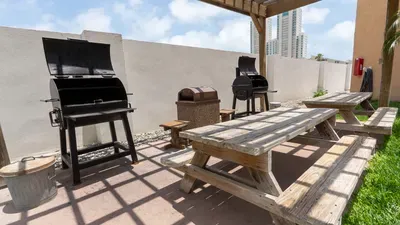 A relaxed outdoor gathering spot with shaded seating and a clean, open layout that feels easy and welcoming. Warm wood tones and simple touches create a comfortable place for guests to unwind, share meals, and enjoy time together.