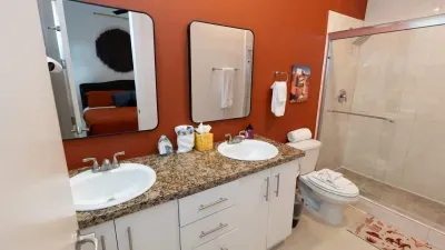 A clean, calming bathroom with warm tones and a tidy double‑vanity setup that feels inviting and well‑kept. Soft lighting, simple décor, and an organized layout create an easy, refreshing space to start and end the day comfortably.
